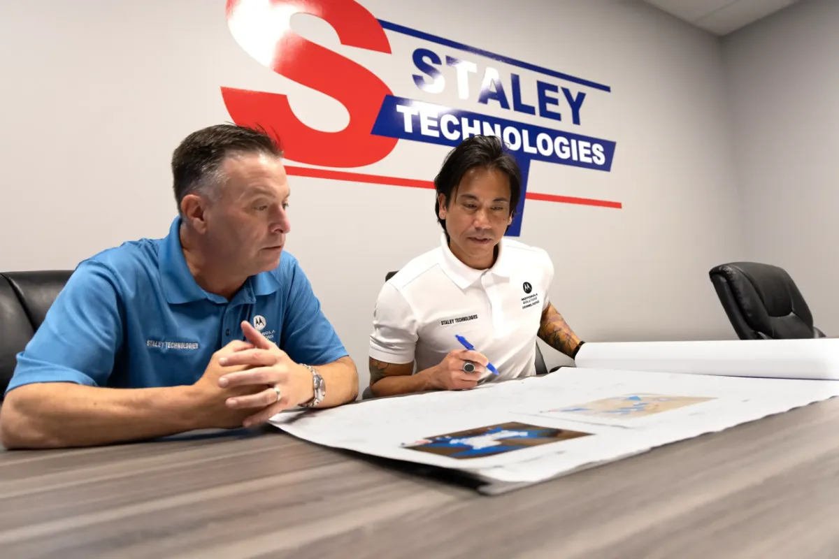 Technologies employees collaborating on integrated security and technology installations.