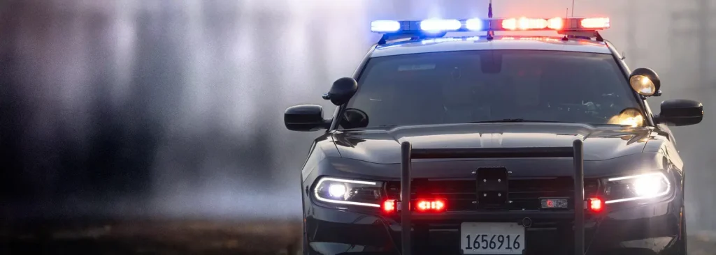 Upfitted police cruiser with push bumper, spotlight, and red and blue emergency lights